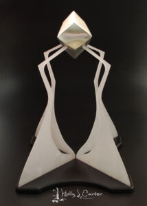 Facets Pewter Sculpture handcrafted by metals Artist Holly J Carter. Pewter Hollow Form on an acrylic and aluminum stand.